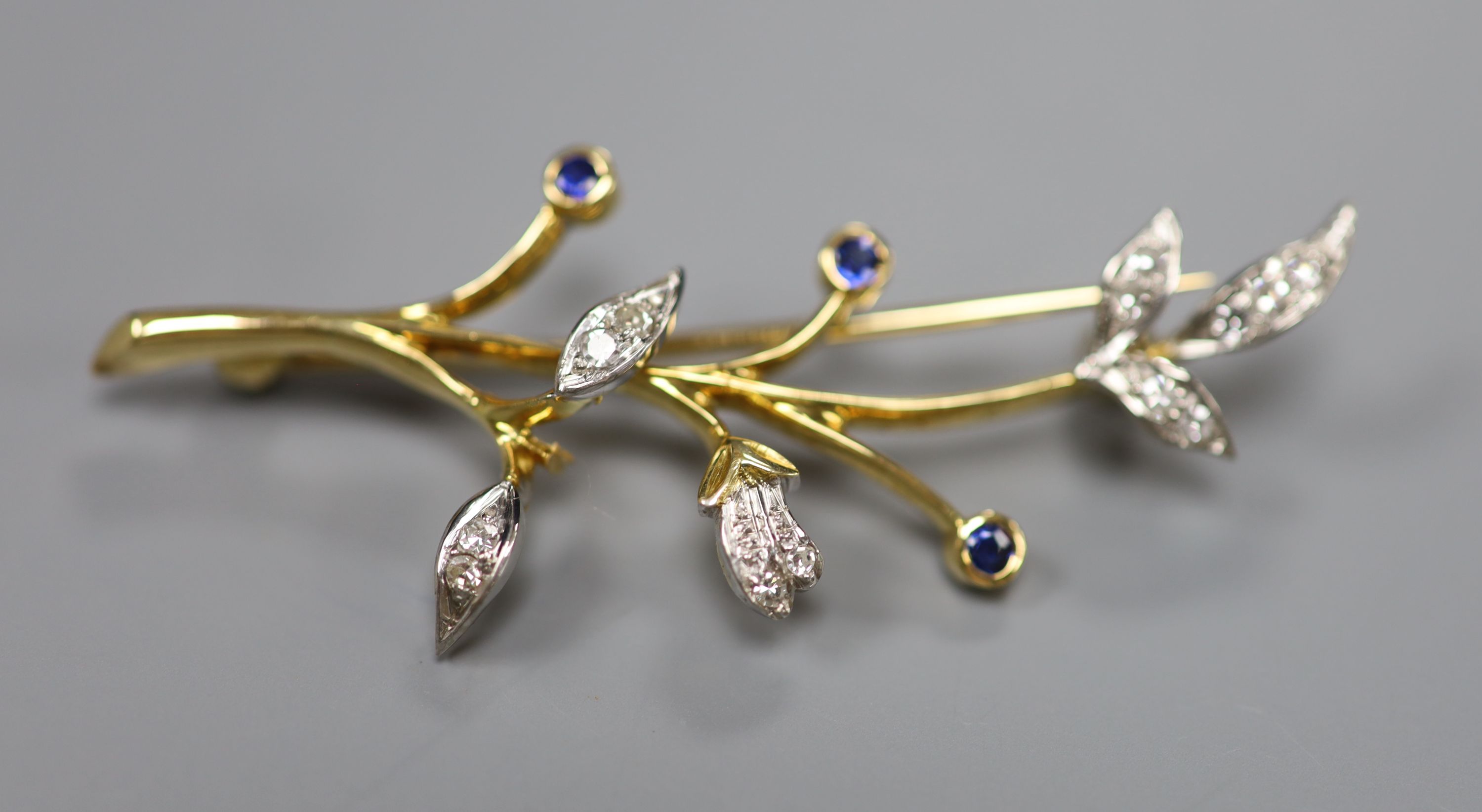 A 1960s 18ct gold, sapphire and diamond set foliate spray brooch, 54mm, gross 6.7 grams.